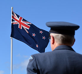 A New Zealand Defence member looking at the New Zealand Flag
