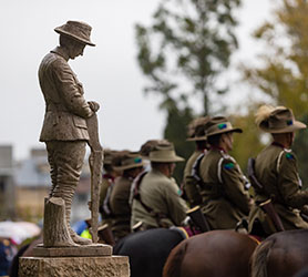 A statue of an Australian Soldier at an ANZAC Day service