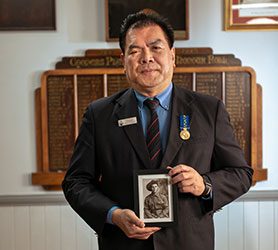 A man holding an image of a veteran